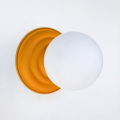 Stepping back into a bygone era with a touch of modern minimalism, the Abeille Sconce or Flushmount in matte mustard is an artistic blend of form and function. This wall sconce doubles as a flushmount ceiling light, making it a versatile lighting solution for any space. Designed akin to a beehive, its charismatic shape is complemented by curated color options that add a playful element to its retro appeal.