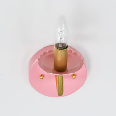 pastel pink and brass wall sconce with scalloped bobesche detail