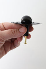 All black daisy drawer pull cabinet or furniture knob. View from the side