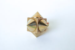 Close-up of a raw brass spike cube knob with a bold, geometric design, featuring four rounded brass spikes on a solid brass cube base.