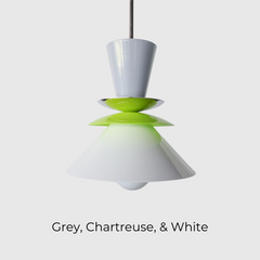 Astro pendant light in a crisp colorblocked palette of grey, chartreuse, and white. This modern ceiling fixture is inspired by mid-century design, featuring stacked powder-coated metal shapes in a sculptural silhouette. The vibrant pop of chartreuse adds playful contrast to the soft neutrals, making it an ideal lighting choice for eclectic, retro, or minimalist kitchens and dining spaces. Designed to stand out, whether used as a single pendant or in a bold row above a kitchen island.