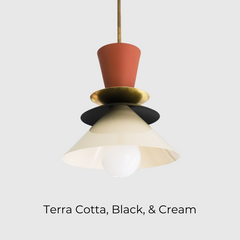 Mid century modern Astro pendant light featuring a colorblocked palette of matte terra cotta, black, and soft cream with a warm brass accent. This sculptural ceiling fixture adds bold yet earthy contrast to kitchens, dining areas, and entryways. Perfect for modern interiors, eclectic spaces, and warm neutral decor lovers looking to elevate their lighting game with something unique and design-forward.