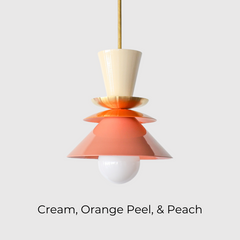 Close-up of the Astro Pendant by Sazerac Stitches, showcasing stacked powder-coated metal shades in cream, orange, and peach. A brass accent plate and white globe bulb complete this retro-inspired design.