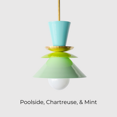 The Astro Pendant light by Sazerac Stitches in a fresh colorway featuring powder-coated finishes in aqua blue, bright lime green, and soft mint green. This playful, geometric lighting fixture is suspended from a brass rod, creating a modern, sculptural statement for any space.