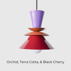 Astro Pendant light fixture designed with layered, powdercoated aluminum shades in orchid purple, matte terra cotta, and deep black cherry. Features a central brass accent and is suspended from a brass rod. Handmade in New Orleans by Sazerac Stitches, this bold ceiling light combines sculptural form with customizable color. Midcentury modern style pendant light perfect for maximalist or eclectic interiors.