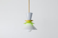 Astro pendant light in a crisp colorblocked palette of grey, chartreuse, and white. This modern ceiling fixture is inspired by mid-century design, featuring stacked powder-coated metal shapes in a sculptural silhouette. The vibrant pop of chartreuse adds playful contrast to the soft neutrals, making it an ideal lighting choice for eclectic, retro, or minimalist kitchens and dining spaces. Designed to stand out, whether used as a single pendant or in a bold row above a kitchen island.