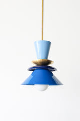 Colorblocked Astro pendant light in hydrangea blue, navy, and Mediterranean blue with a warm brass accent. This sculptural, mid century modern-inspired ceiling fixture adds a bold pop of color to any space. Perfect for eclectic kitchens, creative dining areas, playful living rooms, or vibrant entryways. A statement pendant designed for maximalist interiors, retro-modern homes, or anyone looking to infuse personality and color into their lighting.