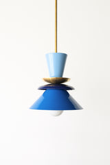 Colorblocked Astro pendant light in hydrangea blue, navy, and Mediterranean blue with a warm brass accent. This sculptural, mid century modern-inspired ceiling fixture adds a bold pop of color to any space. Perfect for eclectic kitchens, creative dining areas, playful living rooms, or vibrant entryways. A statement pendant designed for maximalist interiors, retro-modern homes, or anyone looking to infuse personality and color into their lighting.
