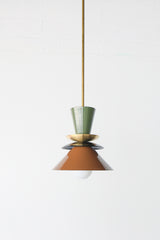 Astro pendant light in olive green, black, and fudge brown with brass accent. A colorblocked mid century modern ceiling fixture with earthy, moody tones. Ideal for warm, vintage-inspired kitchens, eclectic dining rooms, or modern rustic interiors. A bold and timeless lighting choice for statement design lovers.