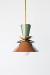 Astro pendant light in olive green, black, and fudge brown with brass accent. A colorblocked mid century modern ceiling fixture with earthy, moody tones. Ideal for warm, vintage-inspired kitchens, eclectic dining rooms, or modern rustic interiors. A bold and timeless lighting choice for statement design lovers.