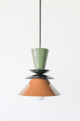 Astro pendant light in olive green, black, and fudge brown with brass accent. A colorblocked mid century modern ceiling fixture with earthy, moody tones. Ideal for warm, vintage-inspired kitchens, eclectic dining rooms, or modern rustic interiors. A bold and timeless lighting choice for statement design lovers.