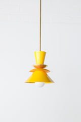 Astro pendant light featuring a bold colorblocked design in bright yellow and matte mustard. A modern statement fixture inspired by mid century modern lighting, perfect for kitchens, dining areas, or eclectic interiors. This handcrafted pendant adds a pop of retro charm and vibrant color, ideal for maximalist home decor or colorful kitchen design.