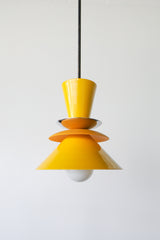 Astro pendant light featuring a bold colorblocked design in bright yellow and matte mustard. A modern statement fixture inspired by mid century modern lighting, perfect for kitchens, dining areas, or eclectic interiors. This handcrafted pendant adds a pop of retro charm and vibrant color, ideal for maximalist home decor or colorful kitchen design.