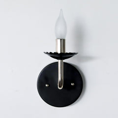 Black and chrome feminine wall sconce with scalloped bobeche detail
