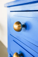 brass mushroom shaped drawer pulls on bright blue nightstand drawers.  Furniture upgrade in a raw brass finish.  Made in New Orleans by Sazerac Stitches