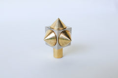 Front-facing view of a spike cube knob with a chrome base and brass spikes, showcasing its contrasting metallic finishes and edgy design.
