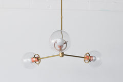 Modern Brass and Glass Chandelier with pops of peach.  Industrial inspired simple brass chandelier for small spaces