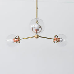 Modern Brass and Glass Chandelier with pops of peach.  Industrial inspired simple brass chandelier for small spaces
