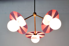 transparent medium pink and brass etched acrylic disc chandelier by sazerac stitches.  perfect Playful light fixture for nursery.