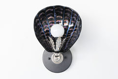 One-of-a-kind hand-painted shell sconce with sculptural black ceramic shade, iridescent brushstroke detailing in violet and copper tones, and silver-toned vintage hardware; unique Art Deco coastal wall light handmade in New Orleans