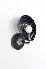 One-of-a-kind hand-painted shell sconce with sculptural black ceramic shade, iridescent brushstroke detailing in violet and copper tones, and silver-toned vintage hardware; unique Art Deco coastal wall light handmade in New Orleans