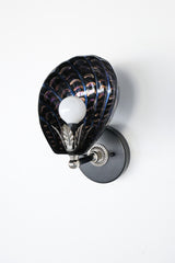 One-of-a-kind hand-painted shell sconce with sculptural black ceramic shade, iridescent brushstroke detailing in violet and copper tones, and silver-toned vintage hardware; unique Art Deco coastal wall light handmade in New Orleans