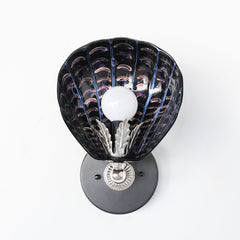 One-of-a-kind hand-painted shell sconce with sculptural black ceramic shade, iridescent brushstroke detailing in violet and copper tones, and silver-toned vintage hardware; unique Art Deco coastal wall light handmade in New Orleans