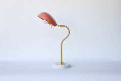 Stylish and versatile desk lamp with an adjustable seashell-shaped shade in a rich peach hue, mounted on a curving brass stem and solid marble base, offering directional ambient light—perfect for nightstands, entry consoles, or maximalist gallery walls.