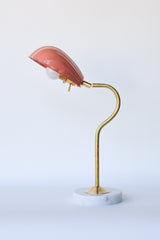 Stylish and versatile desk lamp with an adjustable seashell-shaped shade in a rich peach hue, mounted on a curving brass stem and solid marble base, offering directional ambient light—perfect for nightstands, entry consoles, or maximalist gallery walls.