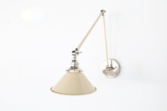 Cream and chrome modern adjustable wall sconce with a cone shade.  Great bedside lighting or wall sconce for above open shelving or cabinets