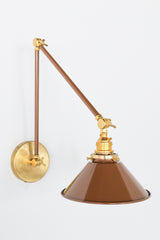 Fudge Brown and Brass adjustable cone sconce for kitchen lighting above windows or above open shelving cabinetry.  Also makes a great bedside reading light that frees up space on your nightstands. Comes in three finishes and over 30 colors for a custom look.  Available in neutrals or fun, bright colors that work in any maximalist or kid-friendly space.  Classic style wall sconce that has been updated by our curated color palette of brights, darks, and pastel hues.  Designed and made by Sazerac Stitches.