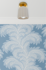 Cream Marcella Flushmount light by Sazerac Stitches, showcasing a wavy-edged ceramic shade and brass hardware, paired with elegant blue and white botanical wallpaper for a refined, coastal-inspired interior style.