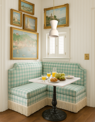 Margot Pendant Light in cream with brass stem, styled in a charming breakfast nook with mint gingham banquette seating, fringe skirt detail, marble-topped café table, and black cast iron pedestal base. Surrounded by gold-framed vintage landscape paintings, white paneled walls, and shuttered window — cozy cottage-inspired dining corner. Handmade modern pendant lighting by Sazerac Stitches, perfect for breakfast nooks, kitchens, and traditional interiors with playful vintage details