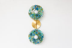 Modern two light wall sconce with brass hardware. Features resin-encapsulated greenery, ferns, and leaves.  Adds a real-like nature theme to any interior design project.  Called the Botanico Sconce by Sazerac Stitches. Features blue & white flowers with white greenery