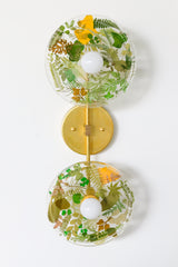 Modern two light wall sconce with brass hardware. Features resin-encapsulated greenery, ferns, and leaves.  Adds a real-like nature theme to any interior design project.  Called the Botanico Sconce by Sazerac Stitches. Features green and yellow leaves & greenery