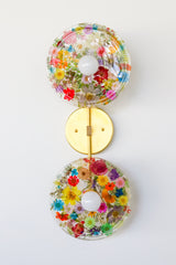 Encapsulated Floral two light wall sconce with flowers in every color flowers and greenery.  Unique wall light with real florals and greenery.  Adds a botanical and nature theme to lighting. Botanico sconce by Sazerac Stitches. multi-colored floral wall sconce light fixture.
