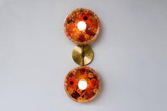 Encapsulated Floral two light wall sconce with orange flowers and greenery.  Unique wall light with real florals and greenery.  Adds a botanical and nature theme to lighting. Botanico sconce by Sazerac Stitches. Orange floral wall sconce light fixture