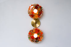 Encapsulated Floral two light wall sconce with orange flowers and greenery.  Unique wall light with real florals and greenery.  Adds a botanical and nature theme to lighting. Botanico sconce by Sazerac Stitches. Orange floral wall sconce light fixture