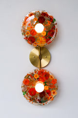 Encapsulated Floral two light wall sconce with orange flowers and greenery.  Unique wall light with real florals and greenery.  Adds a botanical and nature theme to lighting. Botanico sconce by Sazerac Stitches. Orange floral wall sconce light fixture