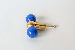 Modern brass and bright Mediterranean blue drawer pull with color-blocked steel balls, perfect for contemporary, eclectic, and maximalist home decor. Handmade in New Orleans, this bold cabinet knob adds a pop of color to kitchens, dressers, or bathroom vanities with its sculptural design and solid brass detailing.