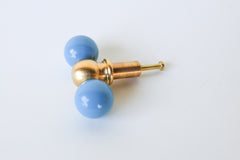 Double Gumball Drawer Pull in hydrangea blue and raw brass, featuring two glossy, powder-coated blue steel spheres flanking a solid brass centerpiece with a warm patina. This colorful, modern drawer knob adds a playful yet sophisticated touch to dressers, cabinets, or built-ins, perfect for eclectic, maximalist, and custom interiors. Handcrafted in New Orleans, this hardware combines contemporary design with artisanal quality and bold color.