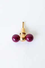 Double Gumball drawer pull in glossy black cherry paired with solid raw brass, handcrafted for a bold and playful look. This statement hardware is perfect for eclectic interiors, maximalist spaces, or colorful kids’ rooms. Made from durable powder-coated steel and high-quality brass that patinas beautifully with age, it adds a unique, eye-catching detail to dressers, nightstands, vanities, and accent furniture. A fun, design-forward knob that elevates any piece with personality and charm.