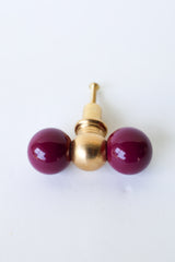 Double Gumball drawer pull in glossy black cherry paired with solid raw brass, handcrafted for a bold and playful look. This statement hardware is perfect for eclectic interiors, maximalist spaces, or colorful kids’ rooms. Made from durable powder-coated steel and high-quality brass that patinas beautifully with age, it adds a unique, eye-catching detail to dressers, nightstands, vanities, and accent furniture. A fun, design-forward knob that elevates any piece with personality and charm.