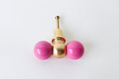 The Double Gumball drawer pull in doll pink and brass is a bold, modern accent for cabinets and furniture. With its playful shape and vibrant color, this oversized knob adds a fun, visual pop to eclectic and maximalist interiors. Handmade in New Orleans from powder-coated steel and raw brass, it’s perfect for kids’ rooms, creative spaces, or anywhere that needs a unique design detail. The brass will develop a natural patina over time, enhancing its charm and warmth.