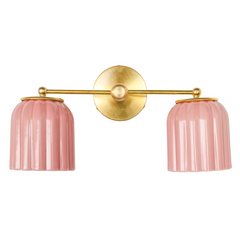 Clean studio image of the Double Marcella Sconce with pastel pink ceramic shades and a warm brass base. Designed and made in the USA, this sculptural wall light highlights Art Deco influence with soft curves and ridged details, perfect for eclectic, modern, or chinoiserie-inspired interiors.