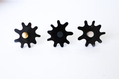 Close-up view of a single Splat drawer pull in black acrylic with a brass detail, highlighting its splat-shaped design and high-quality materials.