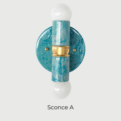 A handcrafted Teal and Grey Marbled Thalia Sconce with dual bulbs, shown against a white wall. The fixture features swirling marbled enamel in soft teal and grey, paired with warm brass hardware. Ideal for modern bathrooms, vanities, or entryways seeking a pop of bold, artistic lighting.