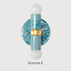A handcrafted Teal and Grey Marbled Thalia Sconce with dual bulbs, shown against a white wall. The fixture features swirling marbled enamel in soft teal and grey, paired with warm brass hardware. Ideal for modern bathrooms, vanities, or entryways seeking a pop of bold, artistic lighting.