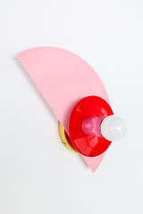 Color-blocked Kin Sconce in blush pink, bold red, and doll pink with brass hardware, photographed on a white wall; perfect for eclectic, maximalist interiors seeking playful wall lighting with a modern pop of color—ideal for kids’ rooms, color-drenched bedrooms, or vibrant hallways.