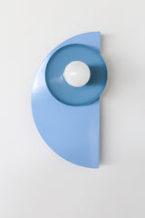 Color-drenched Kin Sconce in celestial blue and hydrangea with a cream socket and brass backplate, ideal for monochromatic bedroom wall lighting or bold hallway installations. A perfect fit for eclectic design lovers seeking playful, sculptural lighting with a modern silhouette and saturated color palette.